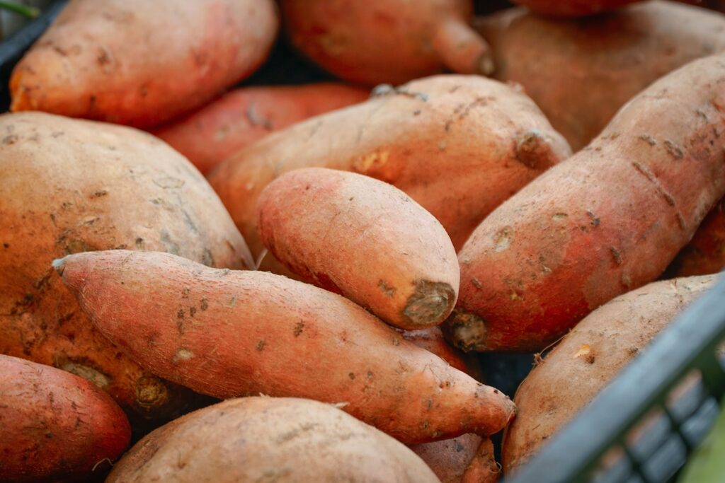 A pile of sweet potatoes in a basket.